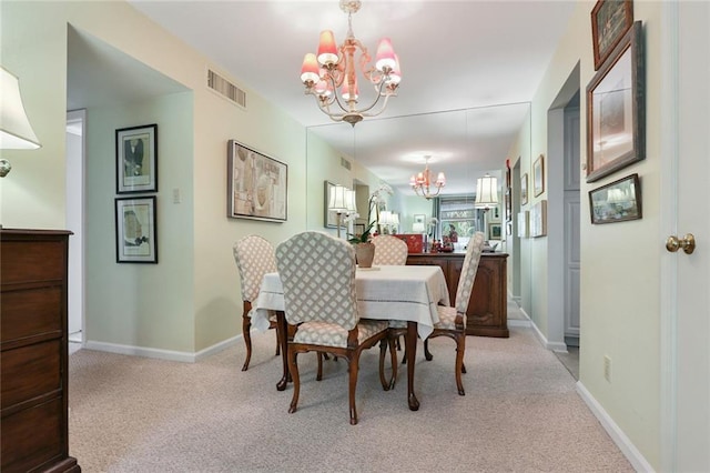 carpeted dining area with visible vents, baseboards, and a notable chandelier