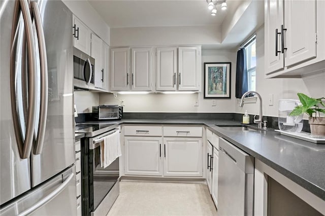 kitchen featuring white cabinetry, stainless steel appliances, and a sink