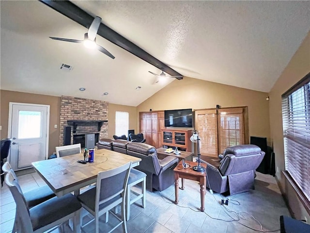 living area with light tile patterned floors, a ceiling fan, a fireplace, vaulted ceiling with beams, and visible vents