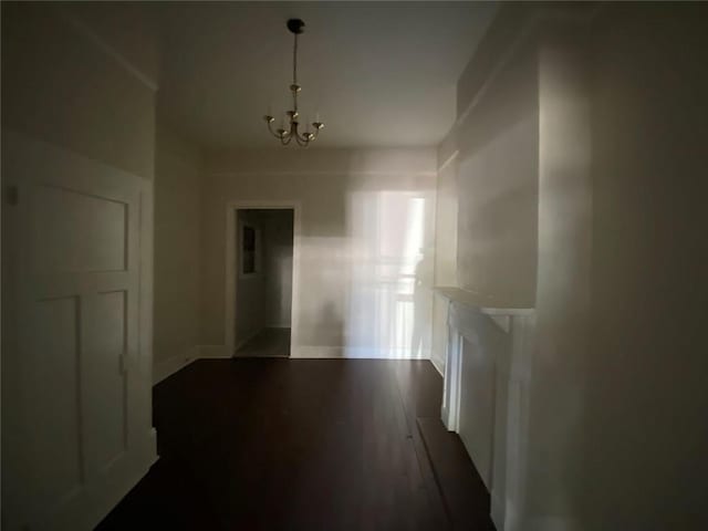 122628 Carondelet St, New Orleans, LA 70130 - unfurnished dining area with baseboards, an inviting chandelier, and dark wood-style floors