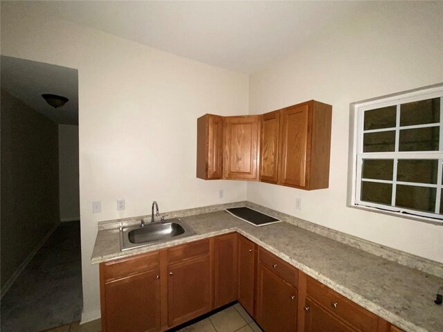122628 Carondelet St, New Orleans, LA 70130 - kitchen with a sink, light countertops, light tile patterned floors, and brown cabinets