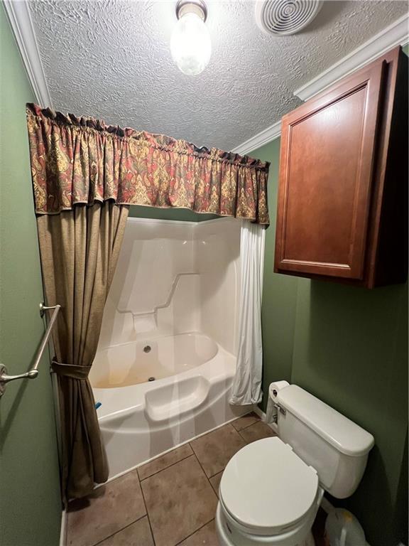 119 Carr Dr, Slidell, LA 70458 - bathroom with shower / tub combo, a textured ceiling, toilet, visible vents, and tile patterned flooring