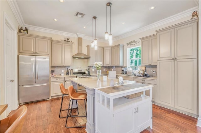 7468 Pitt St, New Orleans, LA 70118 - kitchen featuring a sink, stainless steel appliances, wall chimney range hood, visible vents, and light countertops