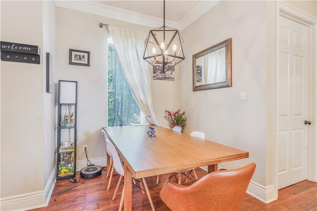 7468 Pitt St, New Orleans, LA 70118 - dining space featuring an inviting chandelier, ornamental molding, baseboards, and wood finished floors