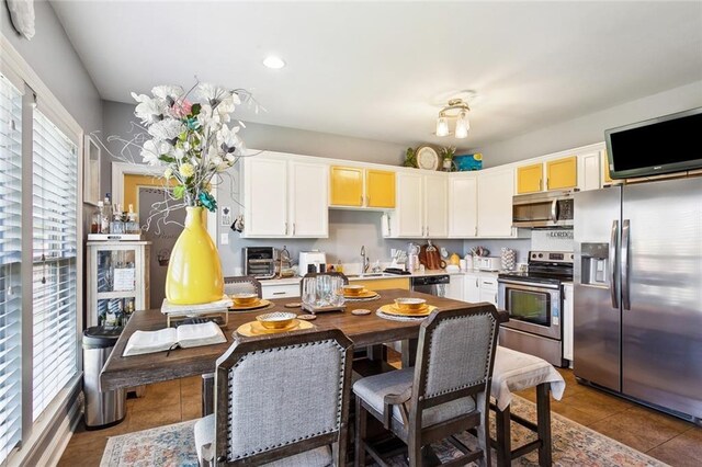 kitchen with appliances with stainless steel finishes, tile patterned flooring, a sink, light countertops, and recessed lighting