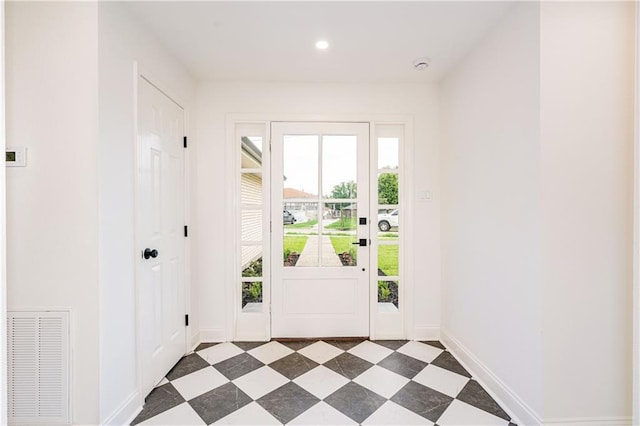 4945 Belle Dr, Metairie, LA 70006 - entryway featuring dark floors, visible vents, baseboards, and a healthy amount of sunlight