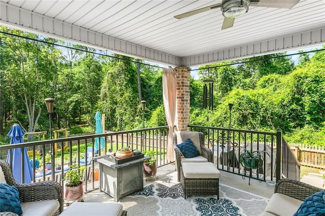 sunroom / solarium with ceiling fan and view of scattered trees