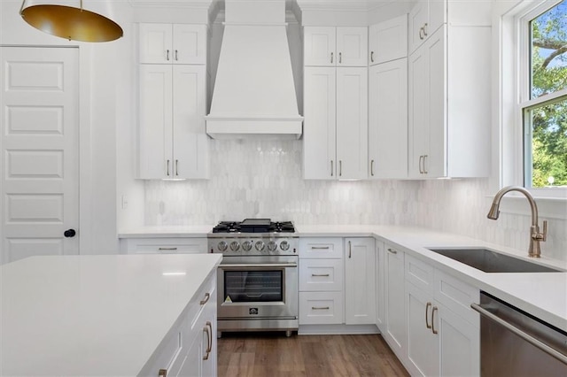 309 W 27th Ave, Covington, LA 70433 - kitchen featuring stainless steel appliances, a sink, premium range hood, light countertops, and white cabinets