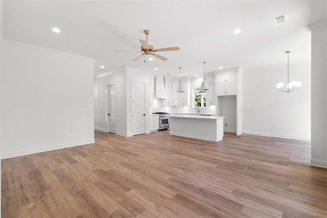 309 W 27th Ave, Covington, LA 70433 - unfurnished living room featuring crown molding, ceiling fan with notable chandelier, visible vents, and recessed lighting