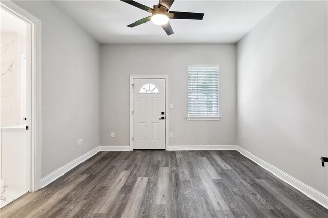 foyer entrance with dark wood-style flooring, baseboards, and ceiling fan