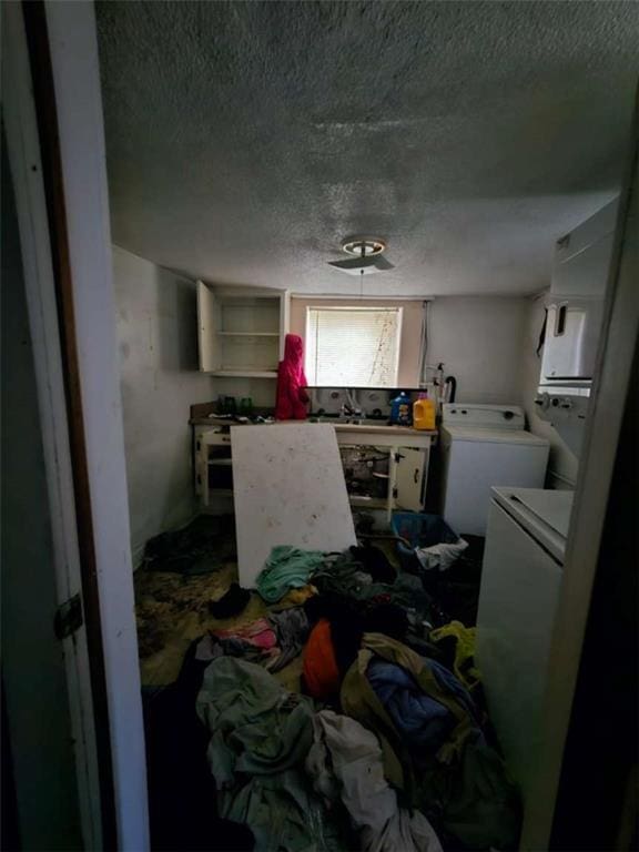 laundry room featuring laundry area, washer and dryer, and a textured ceiling