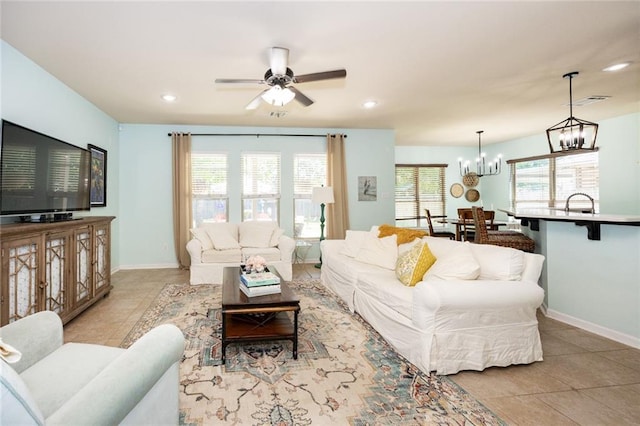 living room with recessed lighting, baseboards, light tile patterned flooring, and ceiling fan with notable chandelier