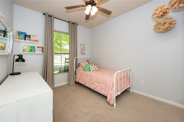 bedroom with light carpet, baseboards, and a ceiling fan