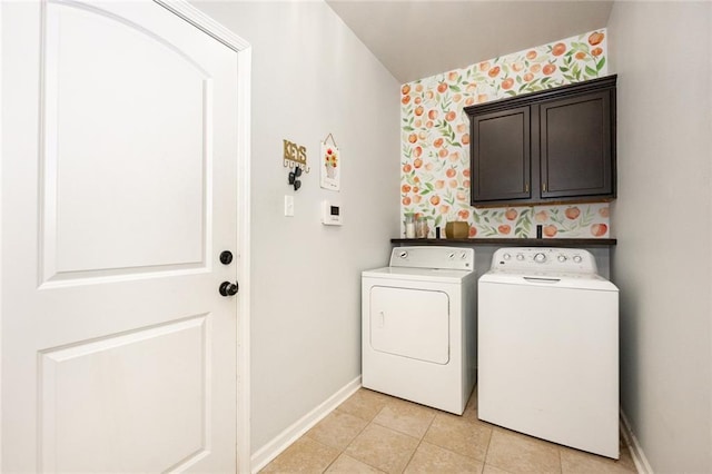 laundry area featuring wallpapered walls, baseboards, light tile patterned floors, washer and clothes dryer, and cabinet space