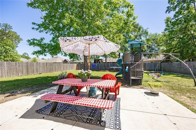 view of patio featuring a fenced backyard, outdoor dining area, and a playground