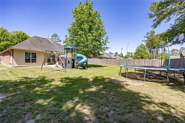 view of yard with a playground, a trampoline, and a fenced backyard