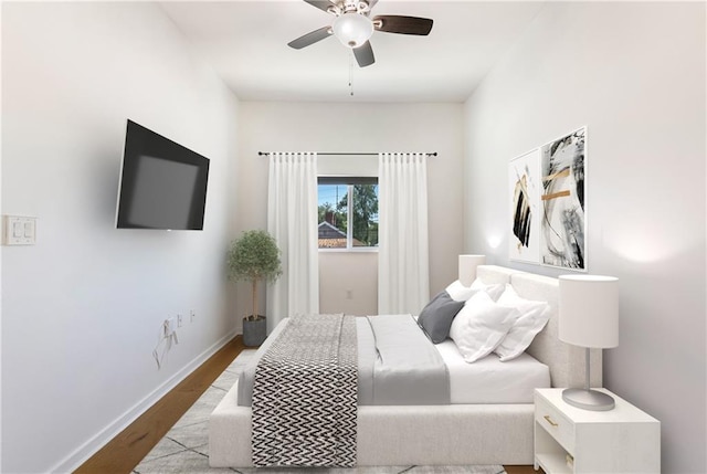 bedroom featuring wood finished floors, baseboards, and a ceiling fan