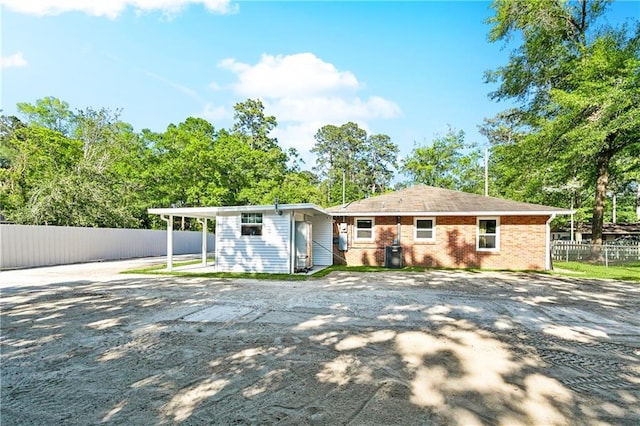 1615 Trechel Dr, Covington, LA 70433 - rear view of property featuring fence, brick siding, and driveway