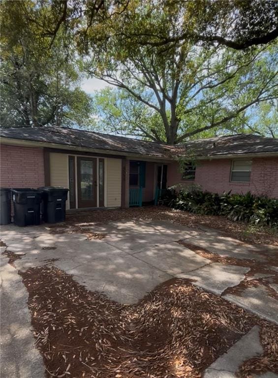ranch-style home featuring a patio, brick siding, and driveway