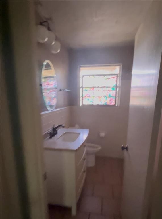 bathroom with toilet, tile patterned flooring, and vanity