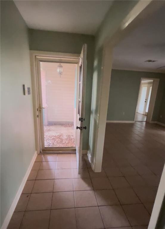 doorway featuring tile patterned floors and baseboards