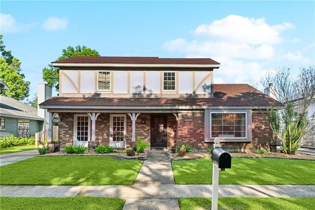 47 Yellowstone Dr, New Orleans, LA 70131 - tudor-style house with a porch, brick siding, and a front lawn