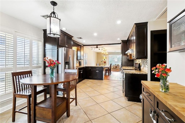 47 Yellowstone Dr, New Orleans, LA 70131 - kitchen with a peninsula, stainless steel fridge with ice dispenser, a chandelier, butcher block counters, and light tile patterned floors