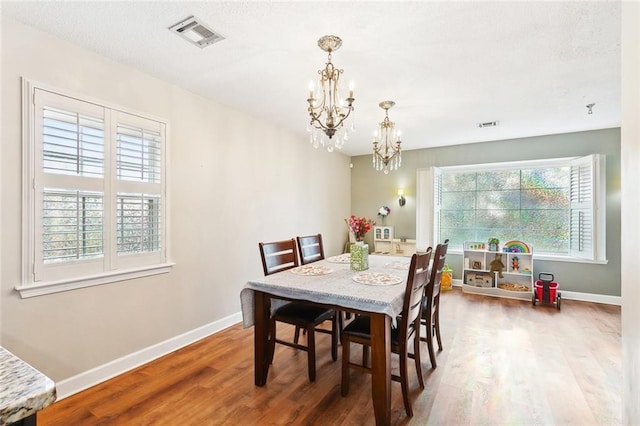 47 Yellowstone Dr, New Orleans, LA 70131 - dining area with a chandelier, wood finished floors, and healthy amount of natural light