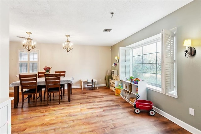 47 Yellowstone Dr, New Orleans, LA 70131 - dining room featuring healthy amount of natural light, a chandelier, light wood-style floors, and baseboards