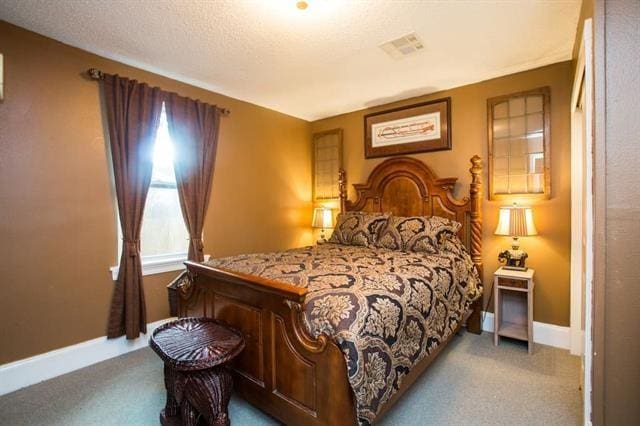 carpeted bedroom with baseboards and visible vents