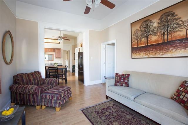 living room featuring a ceiling fan, light wood-style floors, and baseboards
