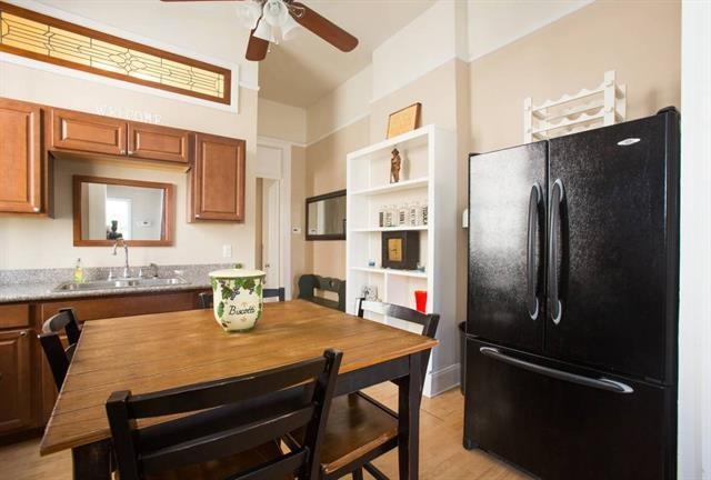 kitchen featuring a sink, freestanding refrigerator, brown cabinetry, light wood-type flooring, and ceiling fan