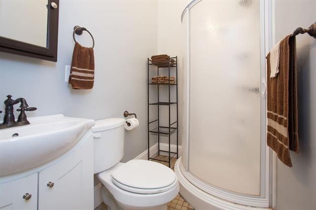 bathroom featuring vanity, toilet, and a stall shower