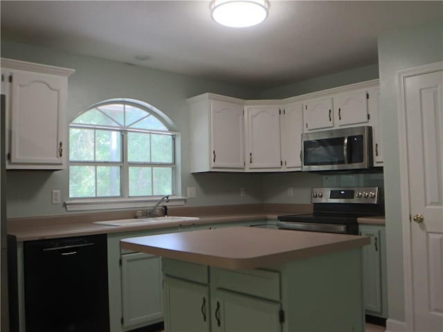 20102 Garland St, Covington, LA 70435 - kitchen with appliances with stainless steel finishes, a sink, a center island, light countertops, and white cabinets