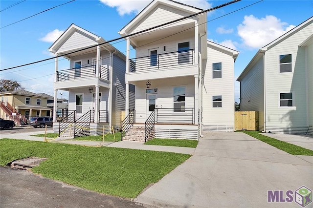 view of front facade with a porch, a front lawn, and a balcony