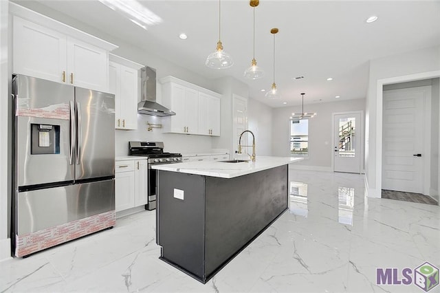 kitchen with appliances with stainless steel finishes, marble finish floor, a sink, and wall chimney exhaust hood
