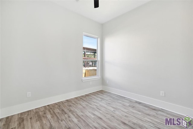 empty room featuring baseboards, wood finished floors, and a ceiling fan