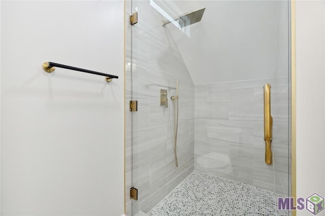 bathroom featuring a stall shower and lofted ceiling