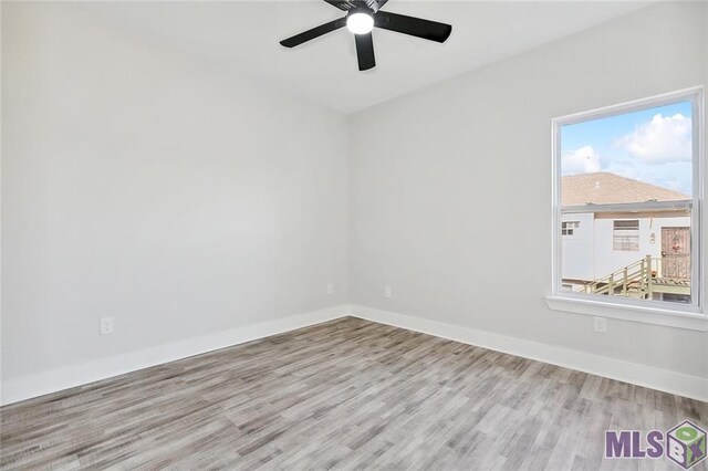 spare room with wood finished floors, baseboards, and ceiling fan