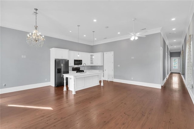2540 Saint Ann St, New Orleans, LA 70119 - kitchen with stainless steel fridge, open floor plan, stove, an island with sink, and light countertops