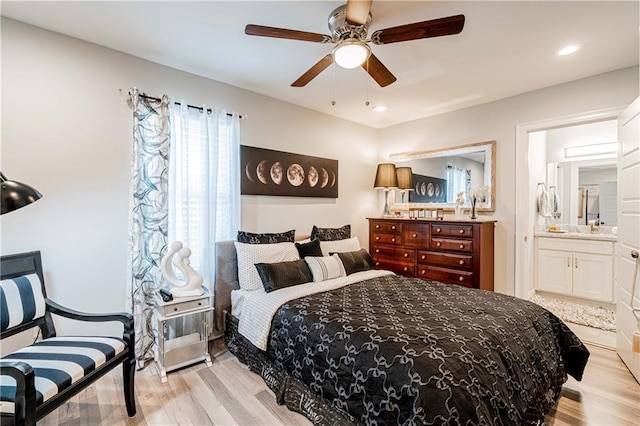 bedroom with light wood-style flooring, ensuite bathroom, ceiling fan, and recessed lighting