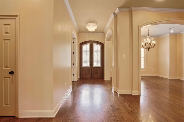 717 Tunica Bnd, Covington, LA 70433 - entrance foyer featuring arched walkways, a chandelier, dark wood-type flooring, baseboards, and ornamental molding