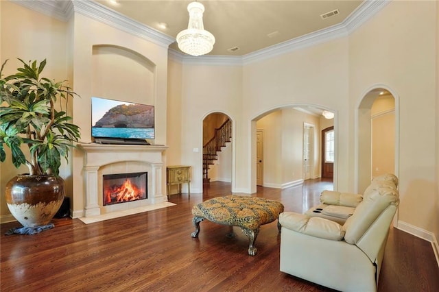 717 Tunica Bnd, Covington, LA 70433 - living area with arched walkways, wood finished floors, crown molding, a fireplace with flush hearth, and baseboards