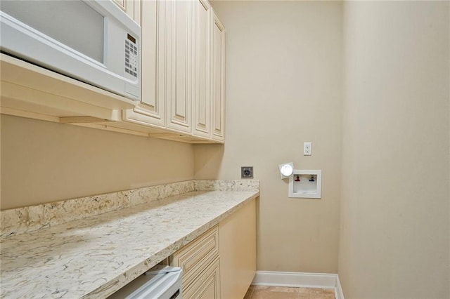 717 Tunica Bnd, Covington, LA 70433 - clothes washing area with electric dryer hookup, washer hookup, cabinet space, and baseboards