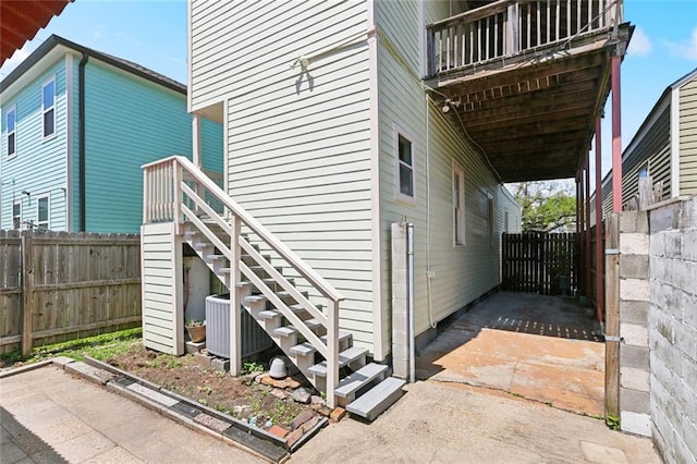 2748 Bienville St, New Orleans, LA 70119 - view of side of property with central AC, fence, stairway, and an attached carport