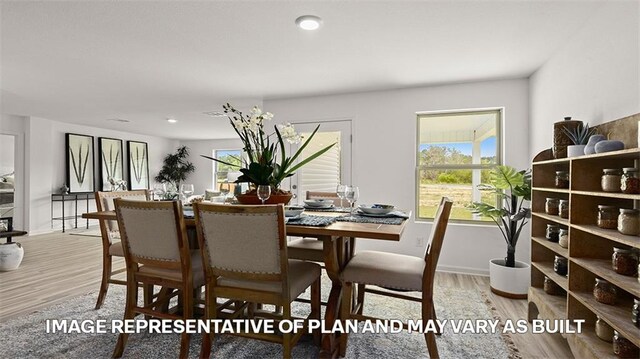 dining room featuring wood finished floors, baseboards, and recessed lighting