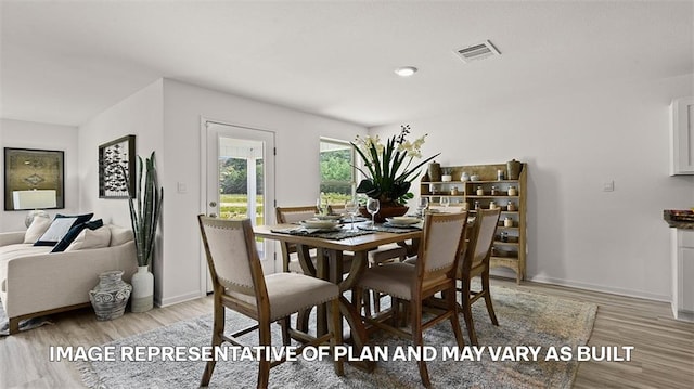 dining space featuring light wood-style floors and baseboards