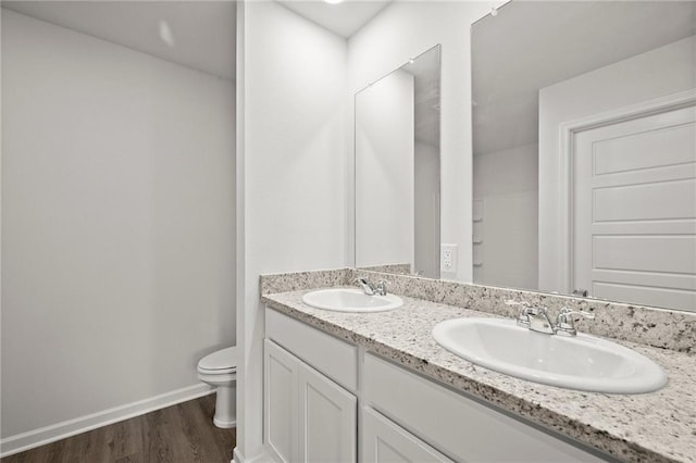 307 Holmes Blvd St, Terrytown, LA 70056 - bathroom featuring toilet, wood finished floors, double vanity, and baseboards