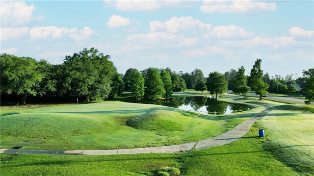 2 Birdie Dr Unit 1D, Slidell, LA 70460 - surrounding community with a water view, golf course view, view of scattered trees, and a lawn
