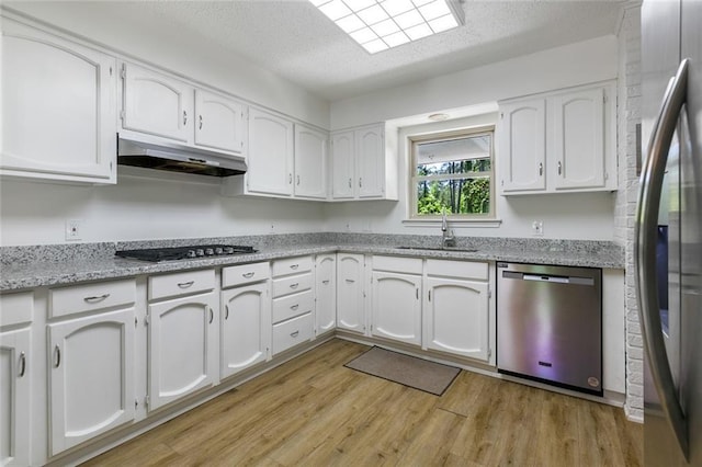 28189 Creole Rd, Lacombe, LA 70445 - kitchen featuring appliances with stainless steel finishes, a sink, under cabinet range hood, a textured ceiling, and white cabinets